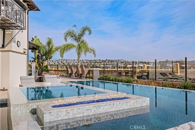 view of swimming pool with a hot tub and a patio