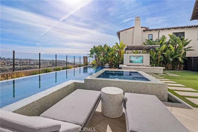 view of pool featuring an in ground hot tub, a water view, and a patio