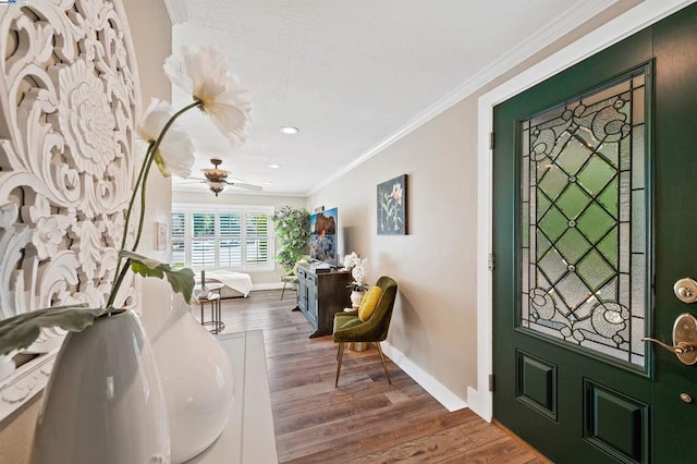 foyer with ceiling fan, ornamental molding, and hardwood / wood-style floors