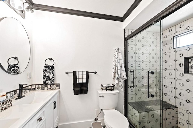 bathroom featuring toilet, ornamental molding, vanity, and a shower with shower door