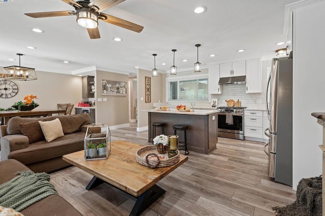 living room featuring crown molding, ceiling fan, and light hardwood / wood-style floors