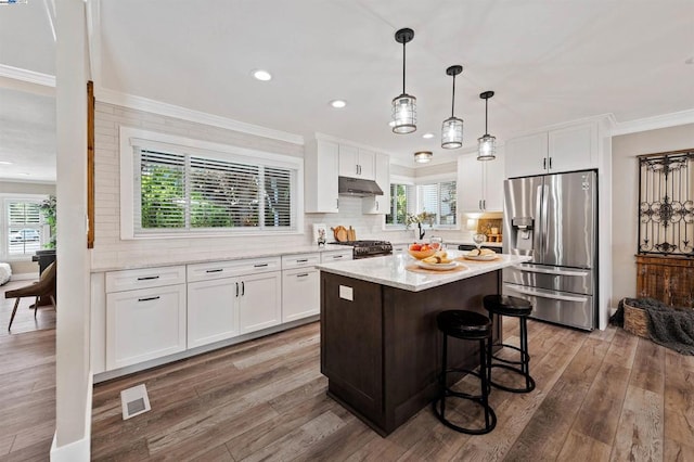 kitchen featuring decorative light fixtures, white cabinetry, a center island, and stainless steel fridge with ice dispenser