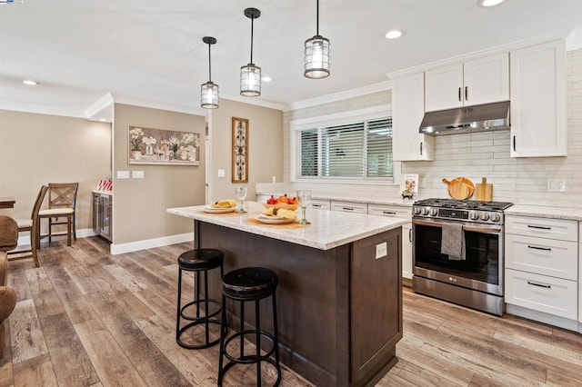 kitchen with white cabinetry, gas stove, and a kitchen island