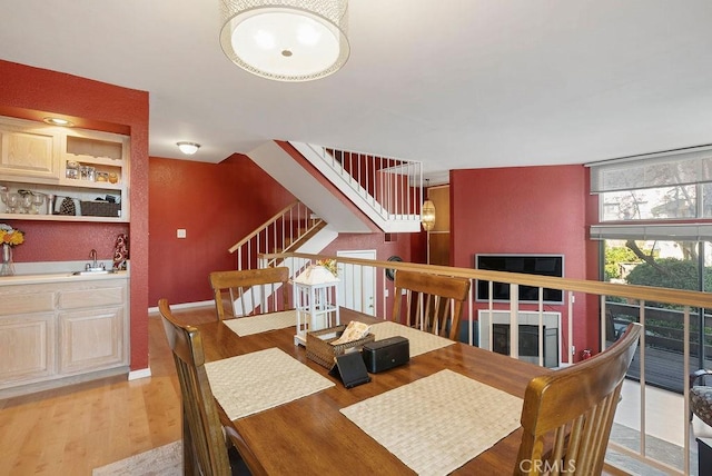 dining room with bar, light hardwood / wood-style floors, and floor to ceiling windows