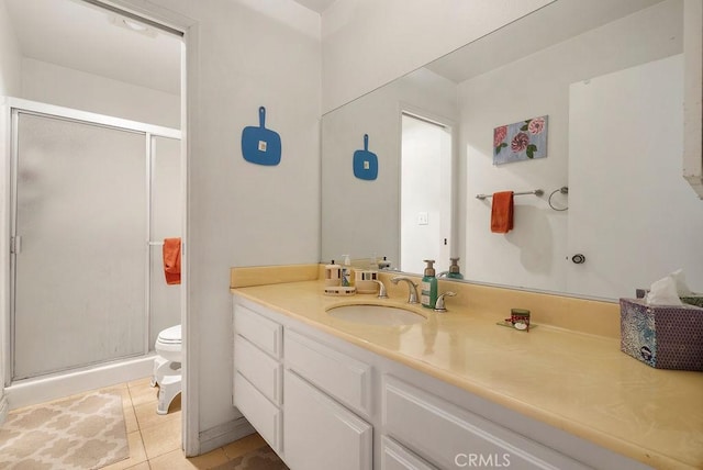 bathroom featuring tile patterned floors, vanity, toilet, and a shower with shower door