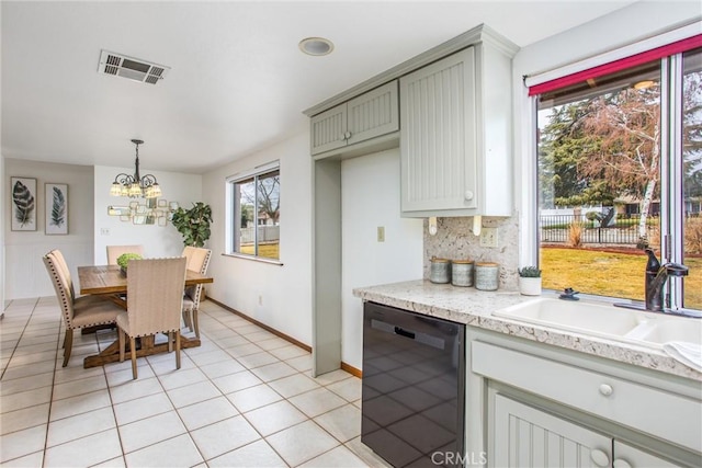 kitchen featuring light tile patterned flooring, sink, black dishwasher, pendant lighting, and backsplash