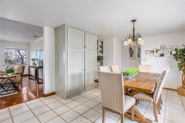 tiled dining room featuring an inviting chandelier