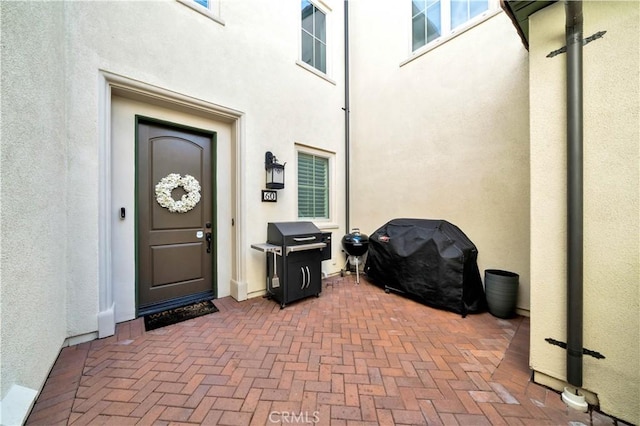 property entrance featuring a patio area and stucco siding