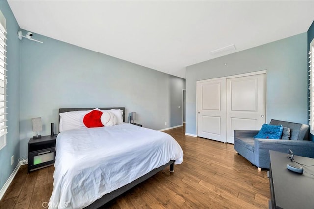 bedroom featuring a closet, baseboards, and wood finished floors