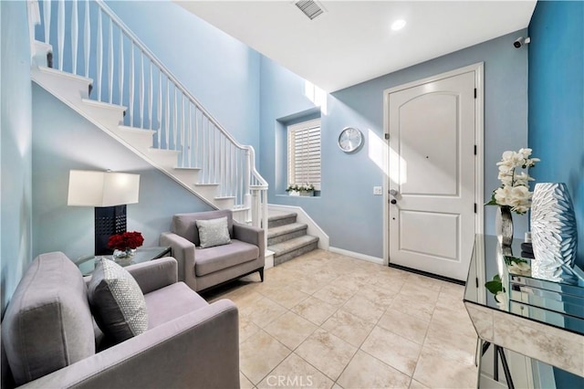 tiled entryway featuring recessed lighting, visible vents, baseboards, and stairs