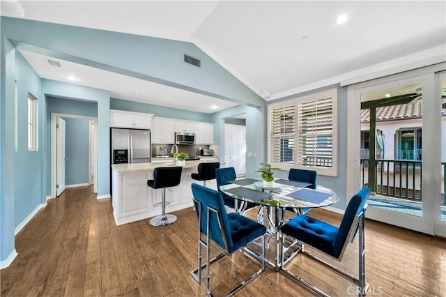 dining area featuring visible vents, baseboards, dark wood-type flooring, and lofted ceiling