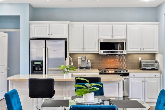 kitchen featuring tasteful backsplash, appliances with stainless steel finishes, white cabinets, and a toaster