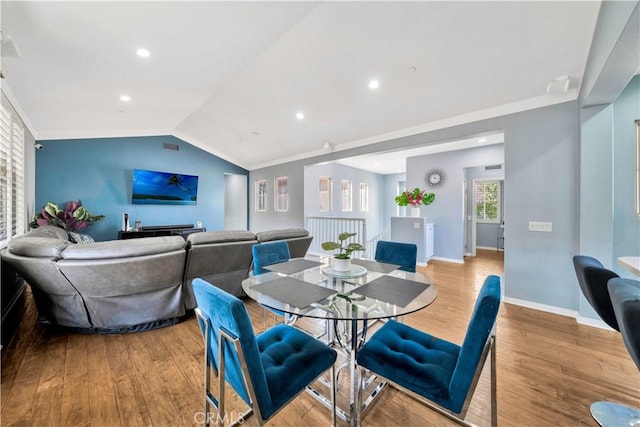 dining space featuring lofted ceiling, ornamental molding, wood finished floors, recessed lighting, and baseboards