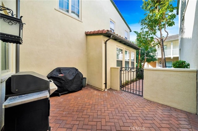 view of patio with area for grilling and a gate