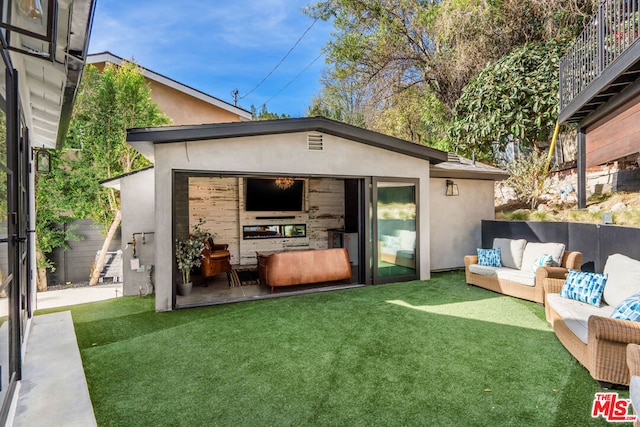 view of outbuilding with an outdoor hangout area and a yard