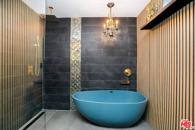 bathroom with tile patterned flooring, tiled shower, tile walls, and a notable chandelier