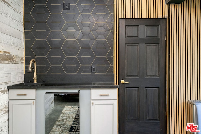 kitchen with white cabinetry, black electric stovetop, and decorative backsplash