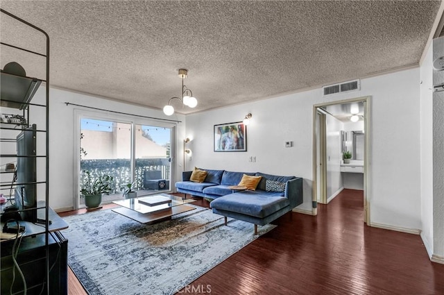 living room featuring an inviting chandelier, dark hardwood / wood-style floors, and a textured ceiling