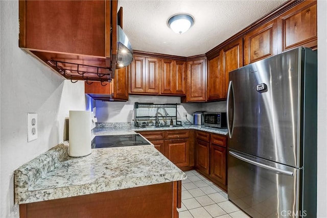 kitchen featuring appliances with stainless steel finishes, sink, light tile patterned floors, and a textured ceiling