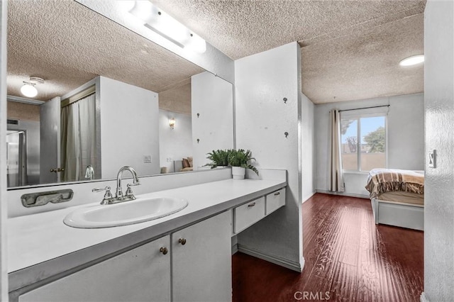 bathroom featuring vanity, hardwood / wood-style floors, and a textured ceiling