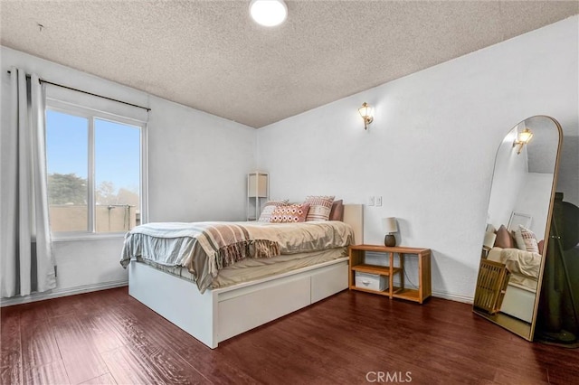 bedroom with dark wood-type flooring and a textured ceiling