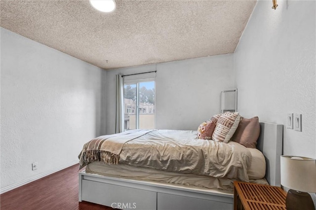 bedroom with dark wood-type flooring and a textured ceiling