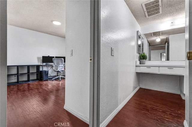 corridor featuring dark hardwood / wood-style flooring and a textured ceiling