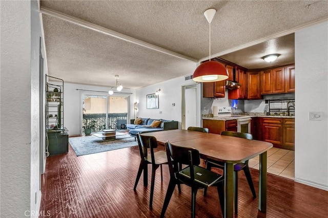 dining space with light hardwood / wood-style floors and a textured ceiling