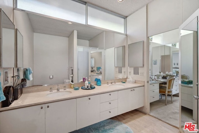 bathroom featuring vanity, wood-type flooring, and a textured ceiling