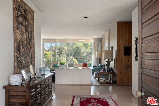 living room with a wall of windows, light hardwood / wood-style floors, and a textured ceiling