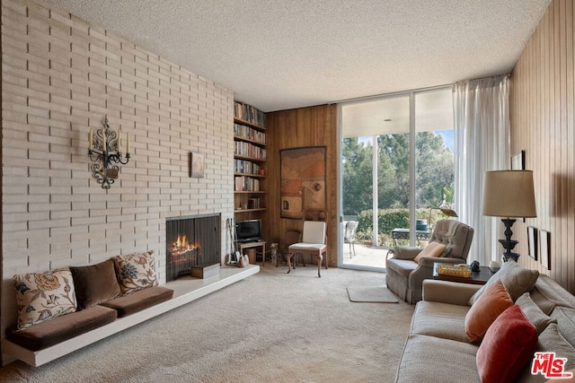 living room with carpet flooring, floor to ceiling windows, a brick fireplace, a textured ceiling, and built in shelves