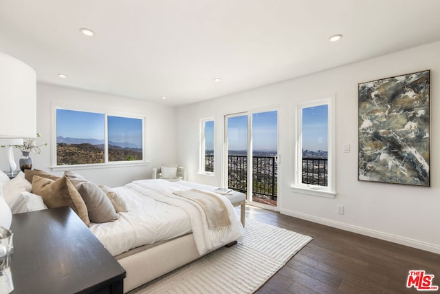 bedroom featuring dark hardwood / wood-style floors, multiple windows, and access to outside