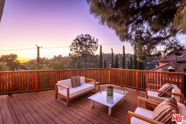 deck at dusk with an outdoor hangout area