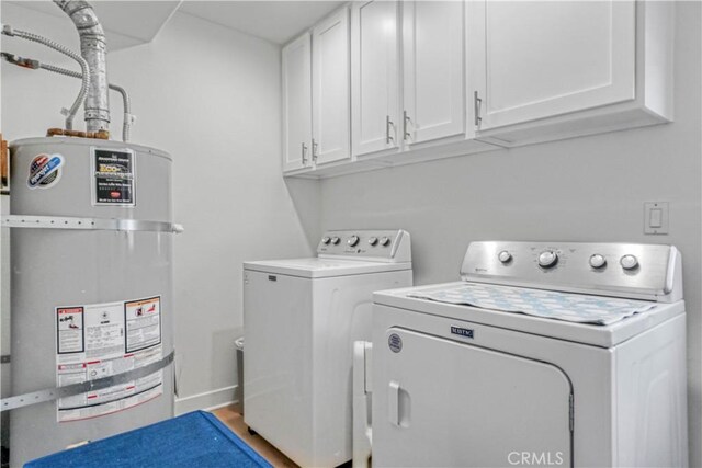 laundry room with water heater, separate washer and dryer, and cabinets