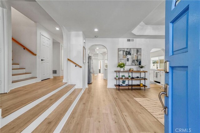 entryway with sink and light hardwood / wood-style flooring