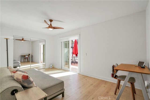 living room featuring light hardwood / wood-style flooring and ceiling fan