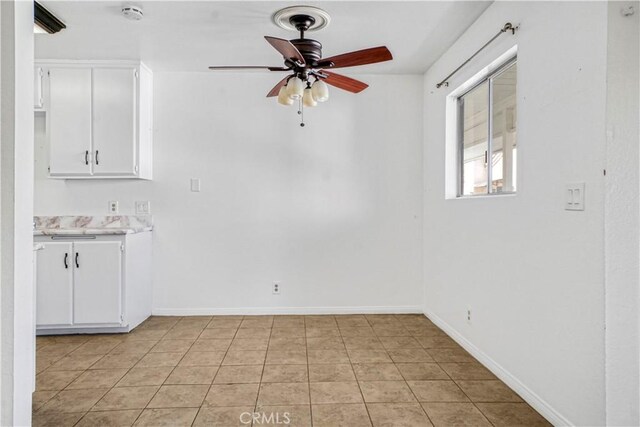 interior space with light tile patterned floors and ceiling fan