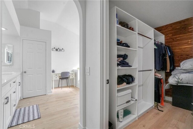 walk in closet with light hardwood / wood-style flooring