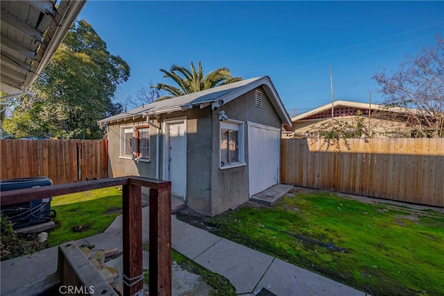 view of side of home featuring an outbuilding and a yard