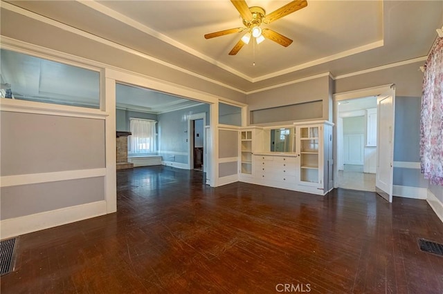 unfurnished living room featuring crown molding, ceiling fan, dark hardwood / wood-style floors, and a raised ceiling