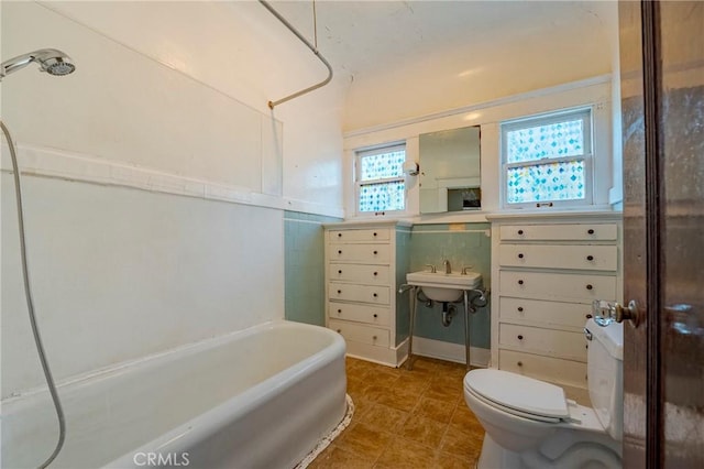 bathroom with tile walls, tile patterned floors, and toilet