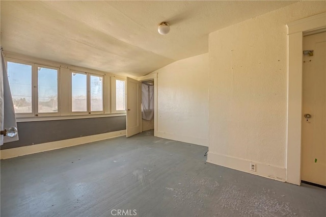 unfurnished room with lofted ceiling