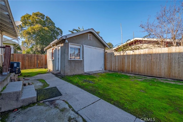 view of outdoor structure with a yard and central AC