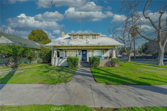 view of front of house with covered porch and a front yard