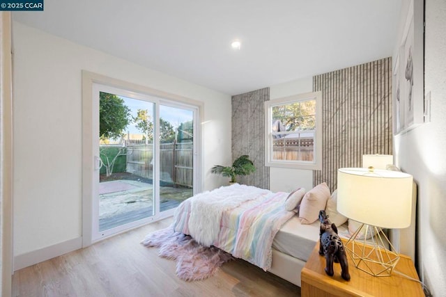 bedroom featuring wood-type flooring and access to outside