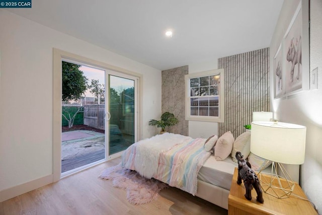 bedroom with wood-type flooring and access to outside