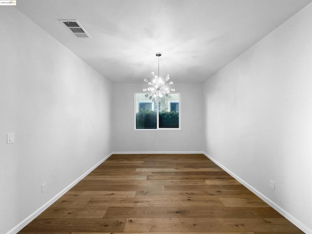 unfurnished dining area with dark wood-type flooring and a chandelier