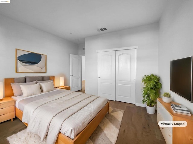 bedroom with dark hardwood / wood-style flooring and a closet