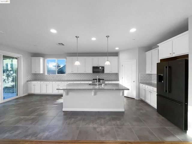 kitchen with a breakfast bar area, hanging light fixtures, black appliances, an island with sink, and white cabinets