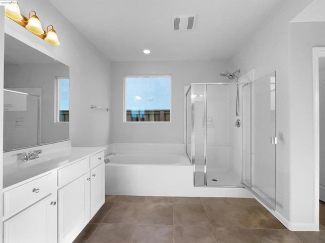 bathroom with tile patterned flooring, plus walk in shower, plenty of natural light, and vanity